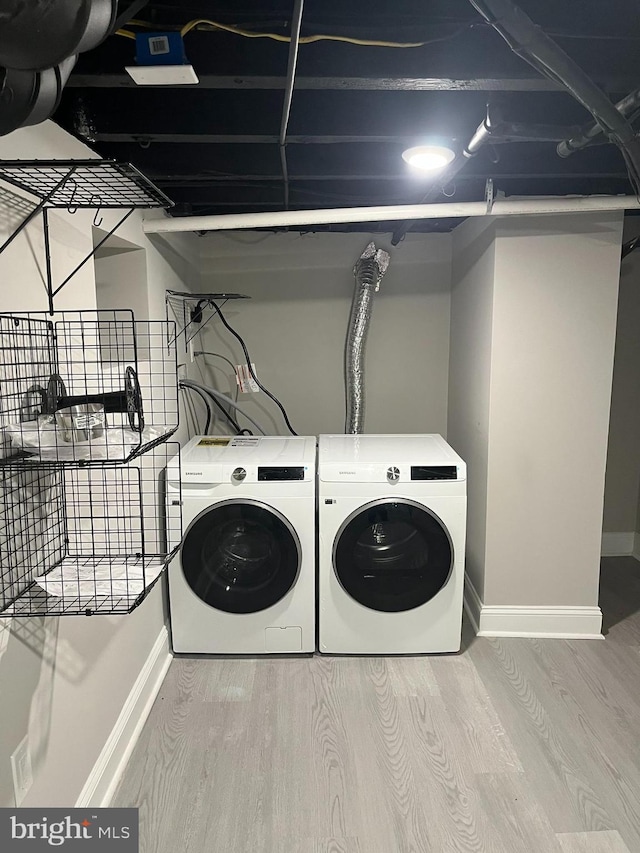 laundry area featuring washer and dryer and hardwood / wood-style flooring