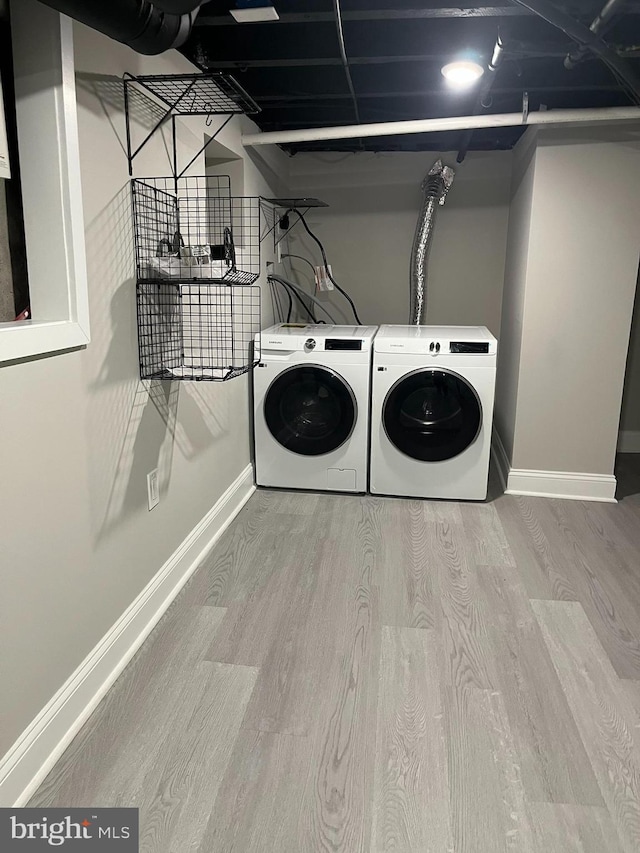 clothes washing area featuring separate washer and dryer and light wood-type flooring