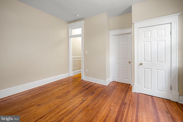 unfurnished bedroom featuring a closet and hardwood / wood-style flooring