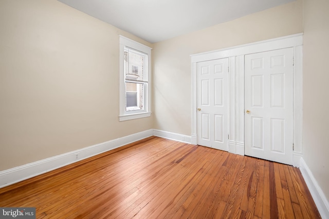 unfurnished bedroom with hardwood / wood-style flooring and a closet