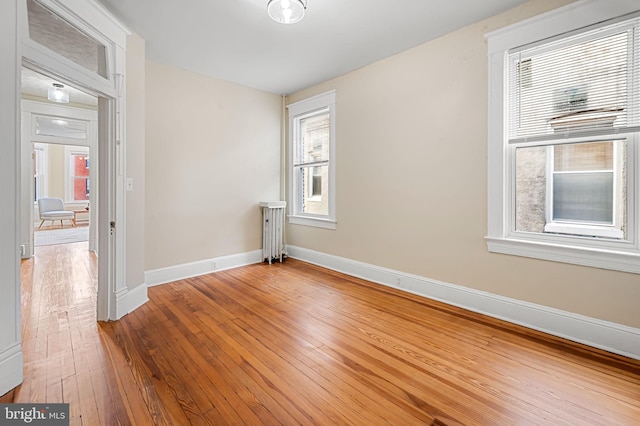 spare room with radiator and hardwood / wood-style floors