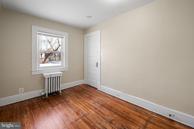 spare room with hardwood / wood-style flooring and radiator