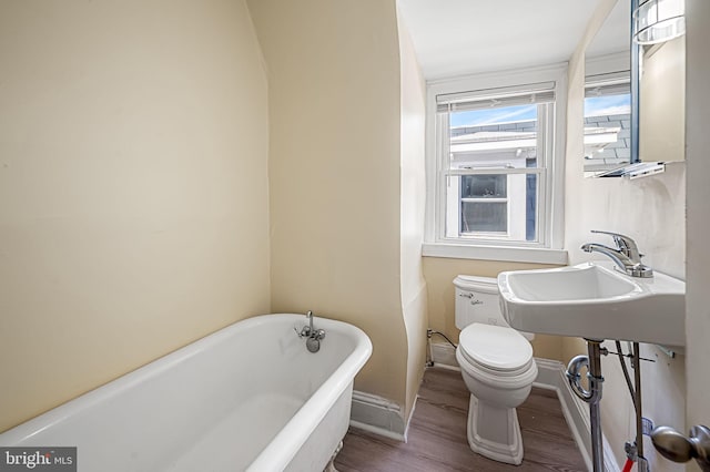 bathroom featuring hardwood / wood-style floors, a bathtub, and toilet