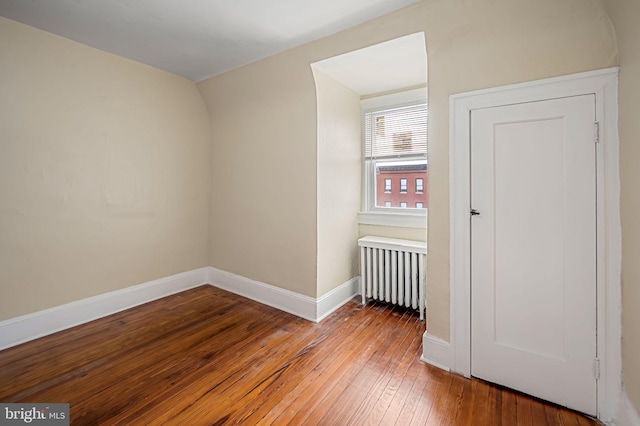 spare room featuring hardwood / wood-style flooring and radiator heating unit