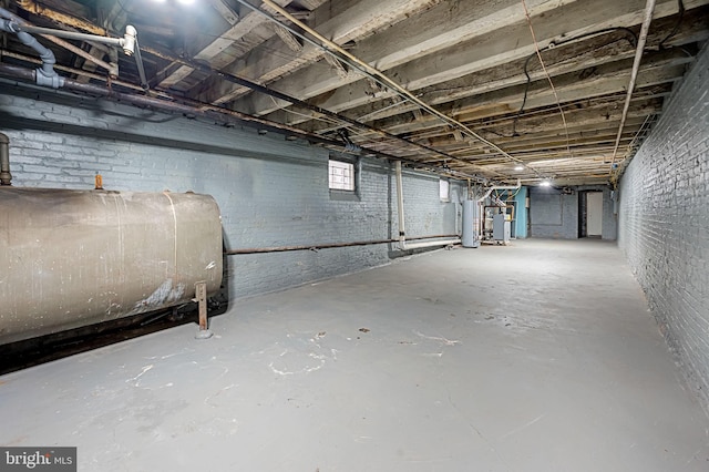 basement featuring gas water heater and brick wall