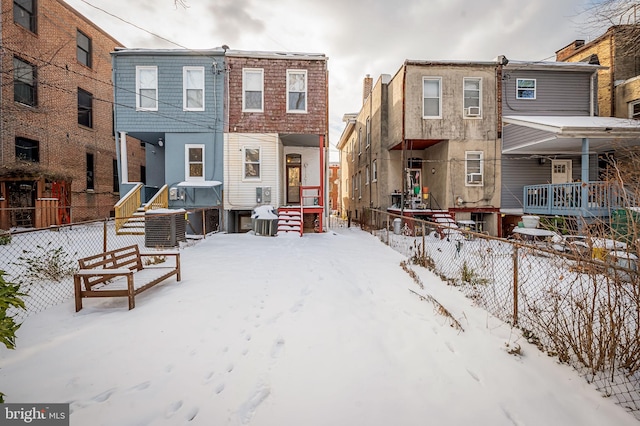 snow covered rear of property with central AC