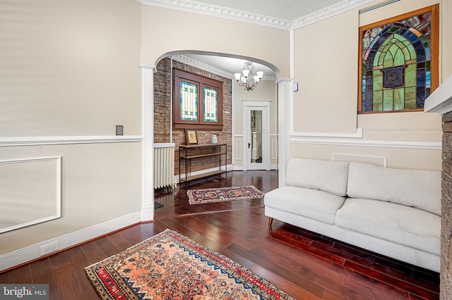 living room featuring hardwood / wood-style floors, a notable chandelier, and crown molding