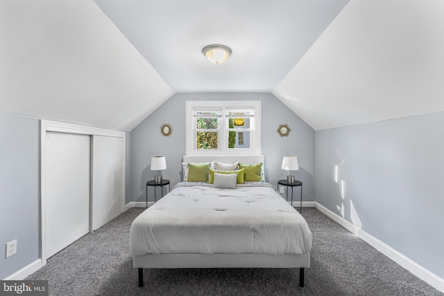 bedroom with carpet floors, vaulted ceiling, and a closet