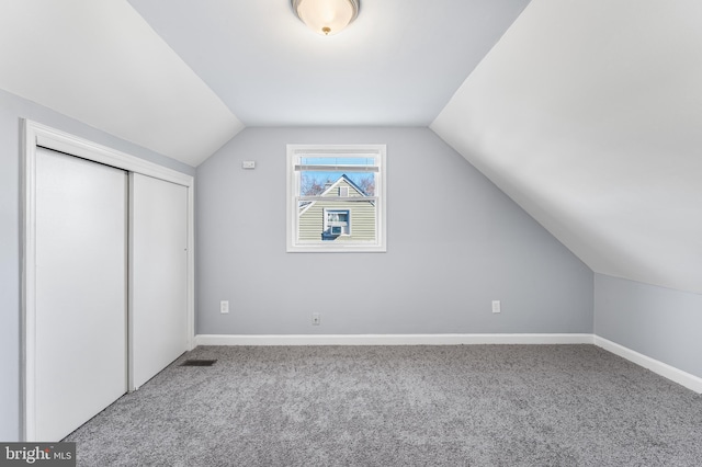 bonus room with carpet flooring and vaulted ceiling