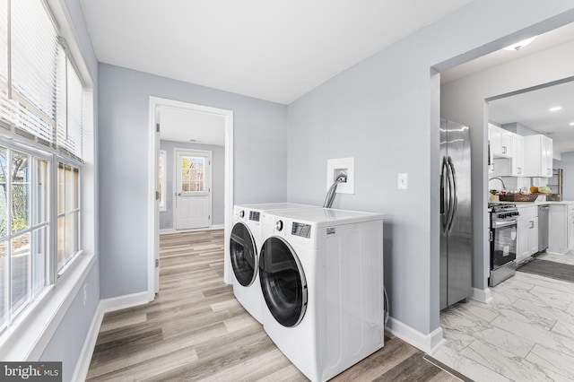 laundry room featuring washer and dryer and light hardwood / wood-style flooring