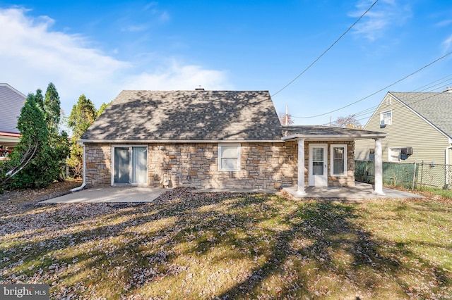 rear view of house featuring a lawn and a patio