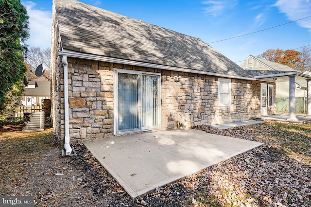 back of property with cooling unit and a patio