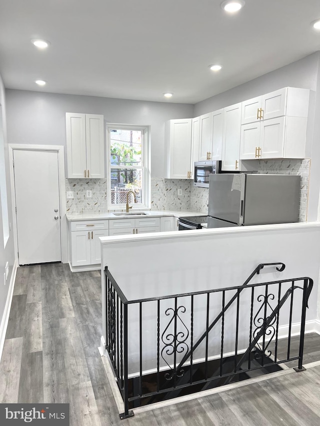 kitchen with white cabinetry, sink, tasteful backsplash, fridge, and dark hardwood / wood-style flooring