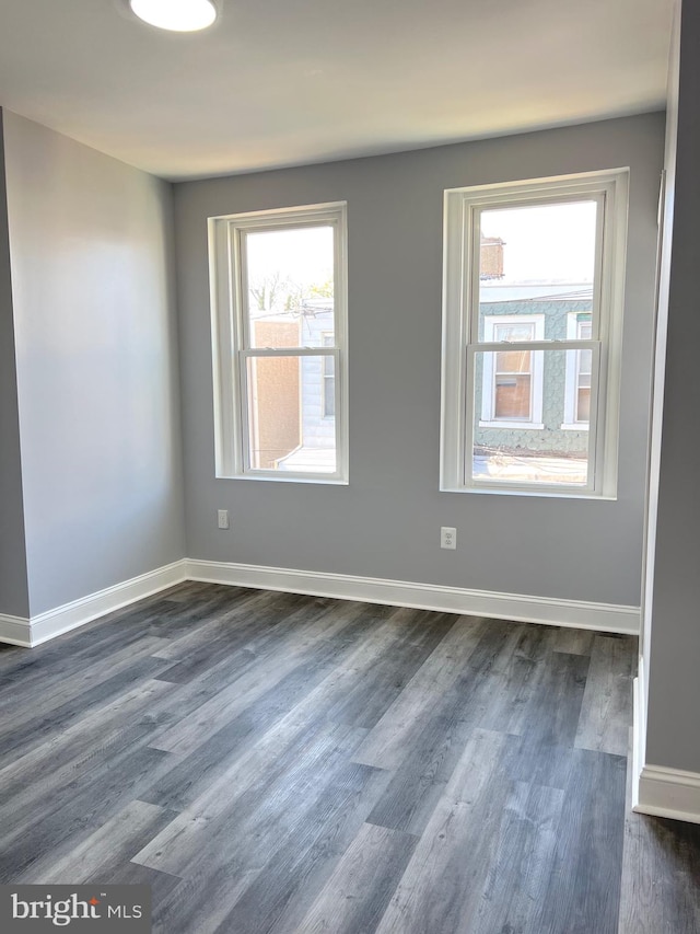 unfurnished room with dark wood-type flooring and a wealth of natural light