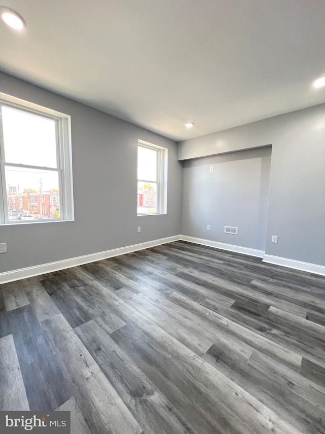 unfurnished room with dark hardwood / wood-style flooring