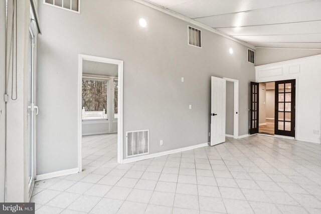 empty room with high vaulted ceiling and french doors