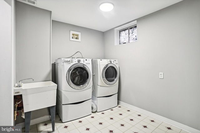 laundry area featuring washing machine and dryer and sink