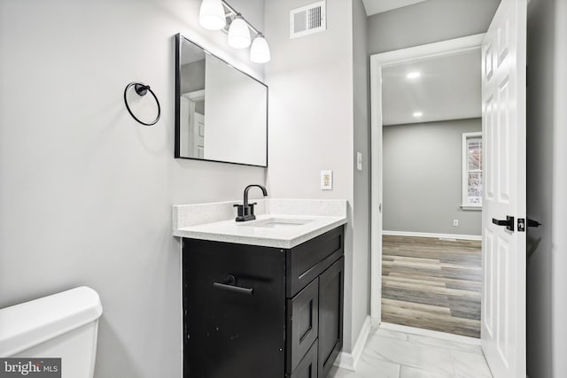 bathroom featuring hardwood / wood-style floors, vanity, and toilet