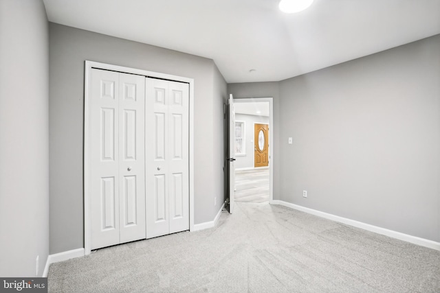 unfurnished bedroom featuring light carpet and a closet