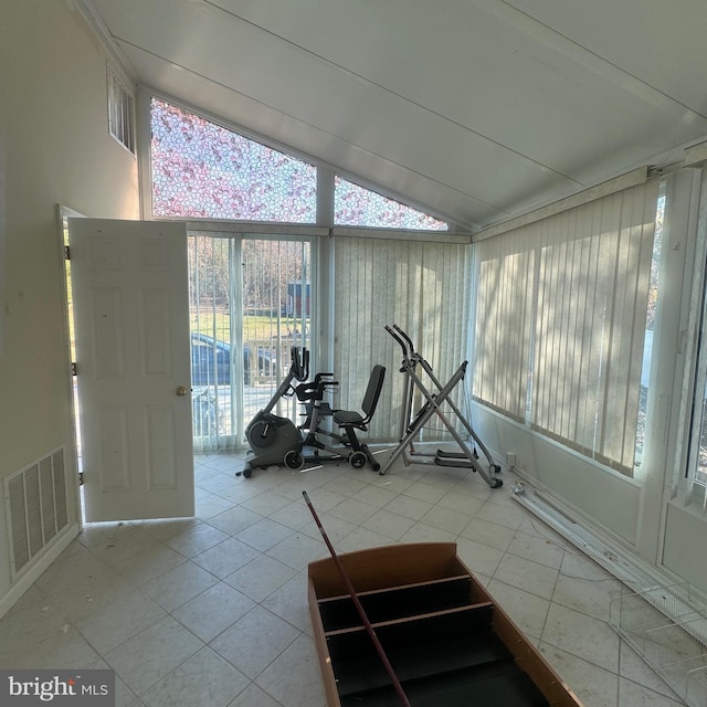 workout area featuring lofted ceiling and light tile patterned flooring