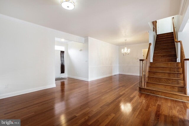 unfurnished room featuring a chandelier, dark hardwood / wood-style floors, and ornamental molding