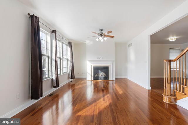 unfurnished living room featuring ceiling fan and wood-type flooring