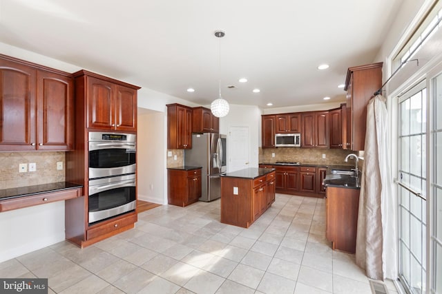 kitchen featuring a center island, sink, stainless steel appliances, pendant lighting, and decorative backsplash