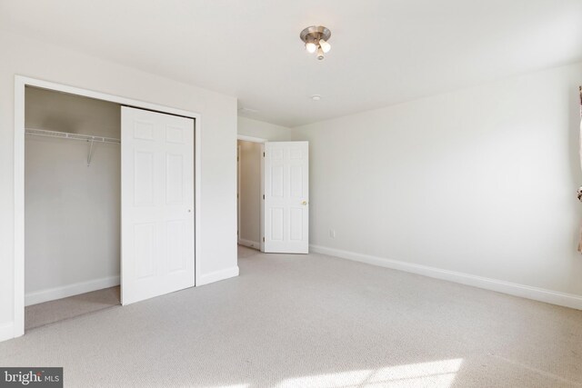 unfurnished bedroom featuring carpet flooring and a closet