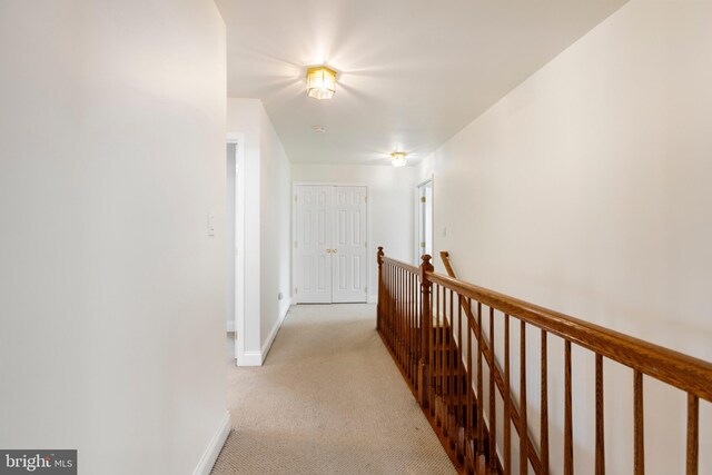 hall with light colored carpet