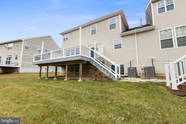 back of property with a lawn, a wooden deck, and central air condition unit