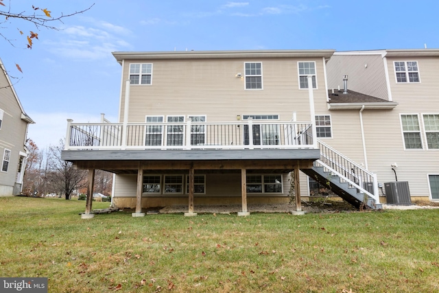 back of property with a wooden deck, a yard, and central AC