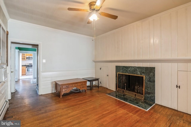 living room featuring a tile fireplace, hardwood / wood-style floors, ceiling fan, and ornamental molding