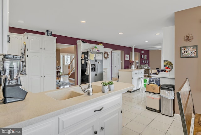 kitchen featuring a center island, white cabinets, kitchen peninsula, light tile patterned floors, and stainless steel fridge with ice dispenser