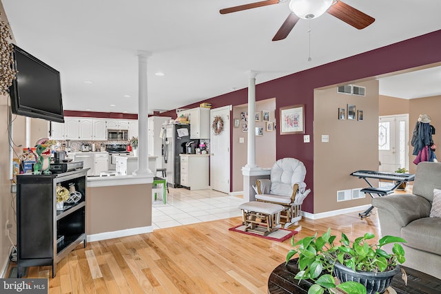 living room featuring light hardwood / wood-style floors, ceiling fan, and decorative columns