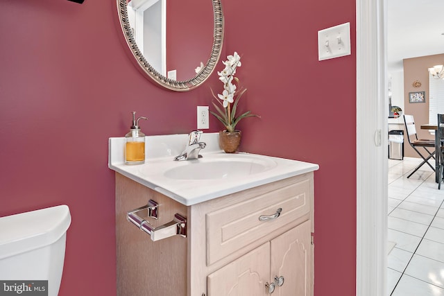 bathroom with toilet, vanity, and tile patterned floors