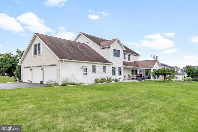 back of house with a garage and a yard