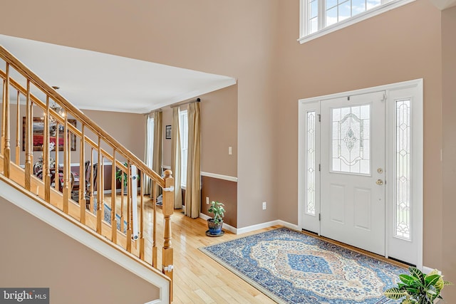 entrance foyer featuring hardwood / wood-style floors, a wealth of natural light, and a high ceiling