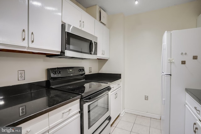 kitchen featuring white cabinets, white fridge, electric range oven, and light tile patterned floors