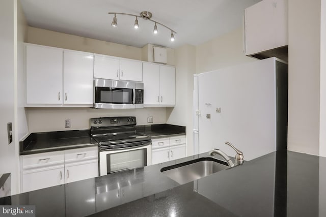 kitchen with range with electric stovetop, sink, and white cabinets