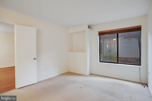 unfurnished room featuring light colored carpet