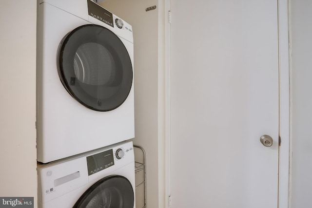 clothes washing area featuring stacked washer and clothes dryer