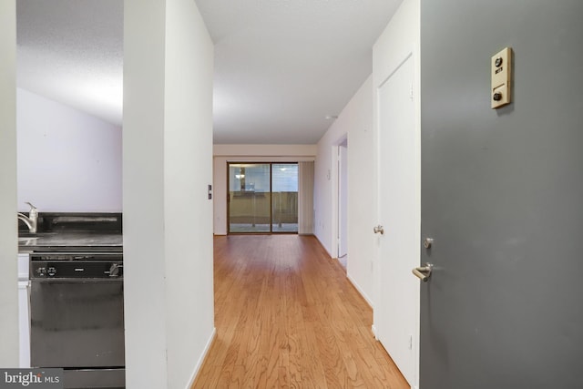 hallway featuring a textured ceiling, light hardwood / wood-style flooring, and sink