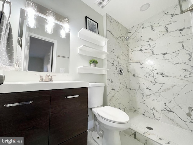 bathroom with vanity, toilet, and a tile shower