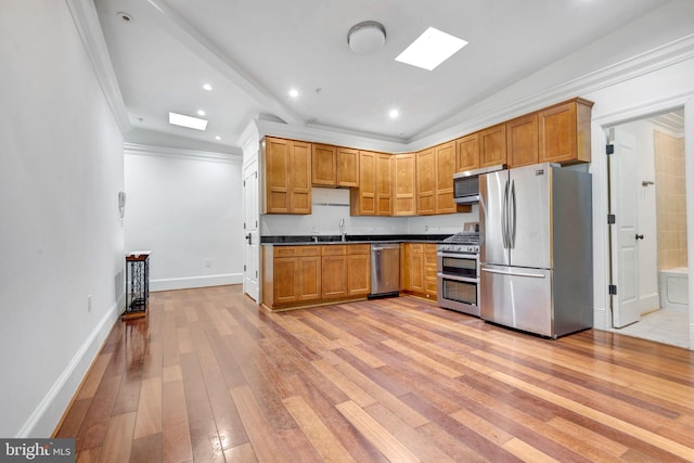 kitchen with crown molding, sink, light hardwood / wood-style floors, and appliances with stainless steel finishes