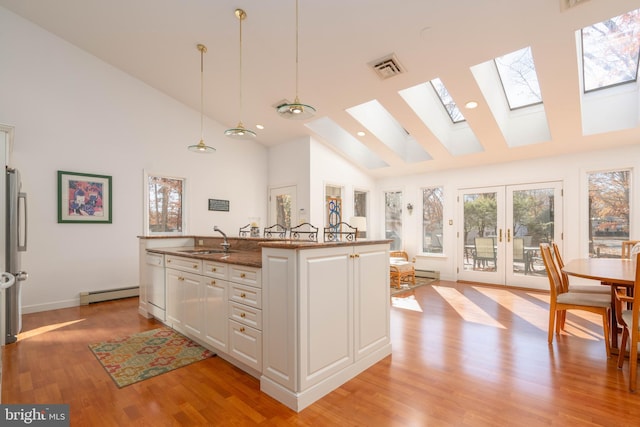 kitchen with white cabinetry, sink, high vaulted ceiling, hanging light fixtures, and a baseboard heating unit