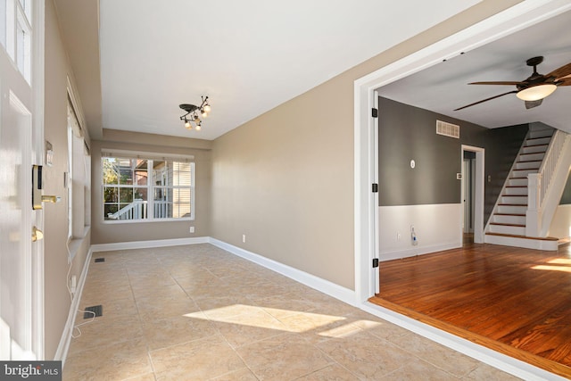 entryway featuring light wood-type flooring and ceiling fan with notable chandelier