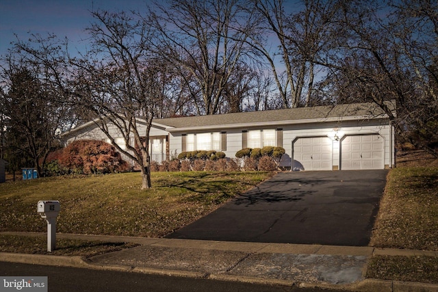 ranch-style house featuring a lawn and a garage