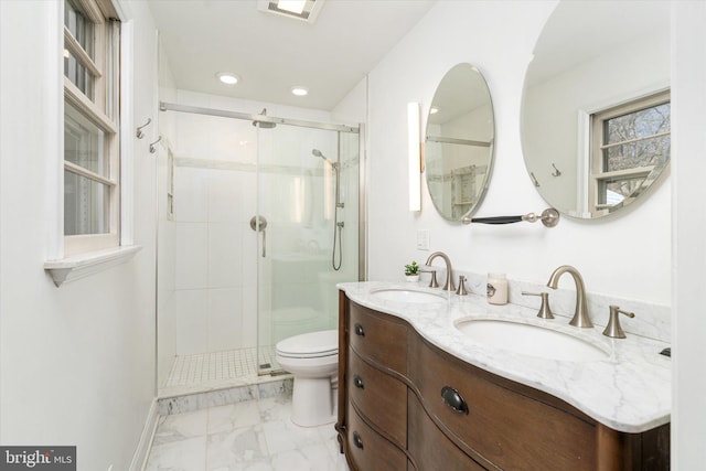 bathroom with a shower with door, vanity, and toilet