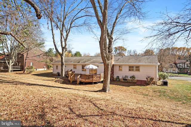 rear view of house featuring a yard and a wooden deck