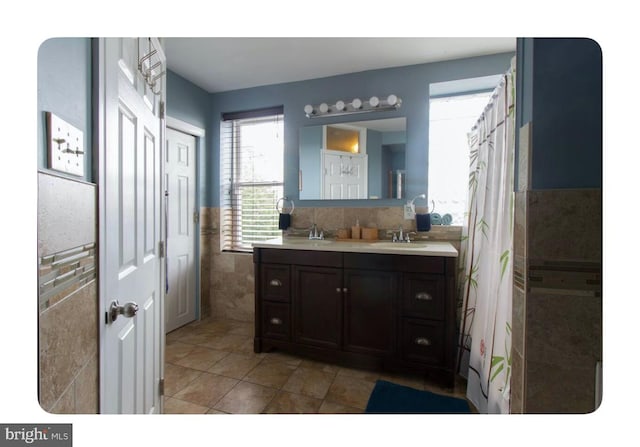 bathroom with tile patterned flooring, vanity, and tile walls